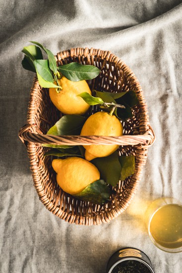 Petit panier en osier contenant des citrons jaunes, vu de dessus