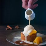 Un gâteau moelleux aux épices et aux agrumes, des clémentines poêlées, de la glace vanille et une crème anglaise aux agrumes et aux épices.