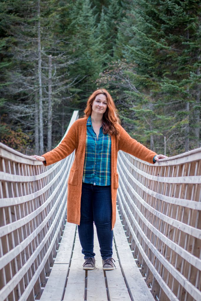 Photo de Valérie Décoret sur un pont au milieu d'une forêt canadienne