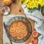 Vue de dessus d'un gâteau renversé à l'orange sanguine. Il est posé sur une grille à gâteaux ancienne sur une table en bois.