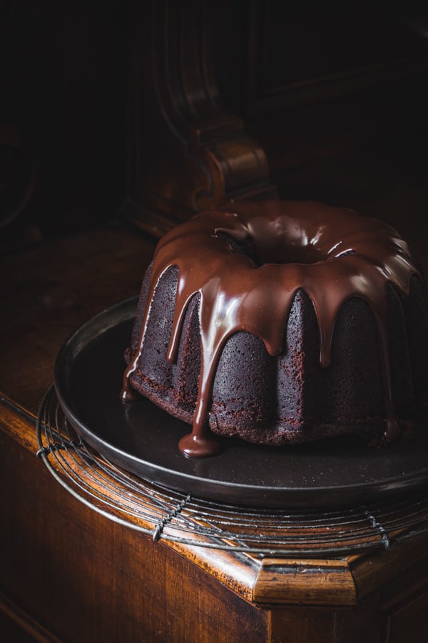 Un glaçage au chocolat bien brillant coule sur un gâteau au chocolat en forme de couronne