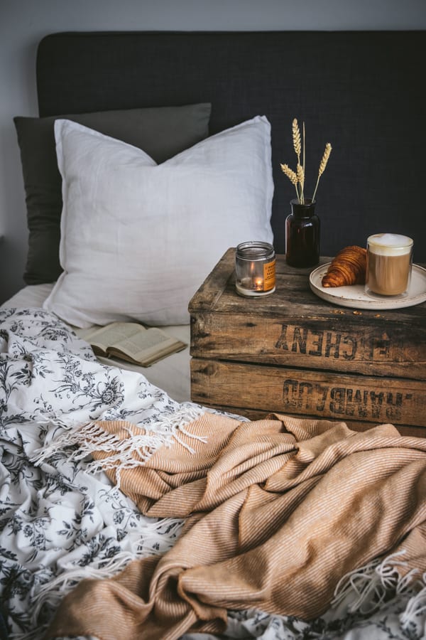 Scène de petit déjeuner au lit en automne avec un croissant et un bon latte noisette